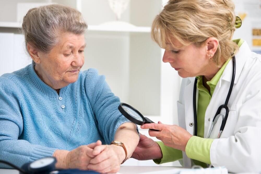 Doctor checking old woman's skin