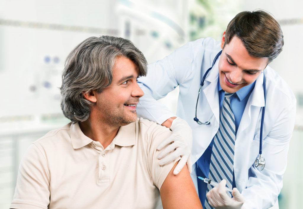 Doctor Injecting A Male Patient