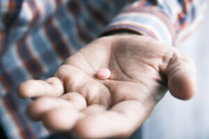 Open hand with medicine pill. 