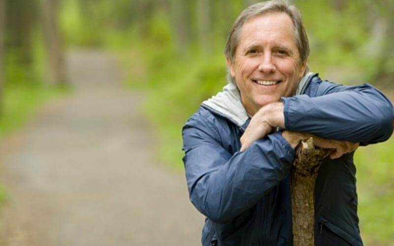 Middle-aged man sitting and smiling directly at camera