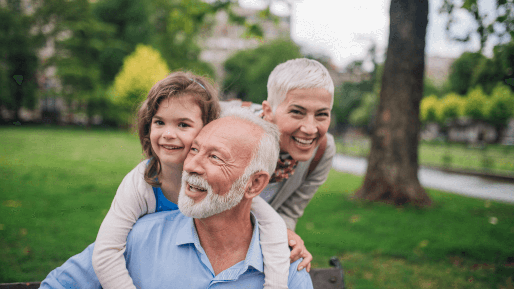 middle-aged couple and their grandchild playing and smiling