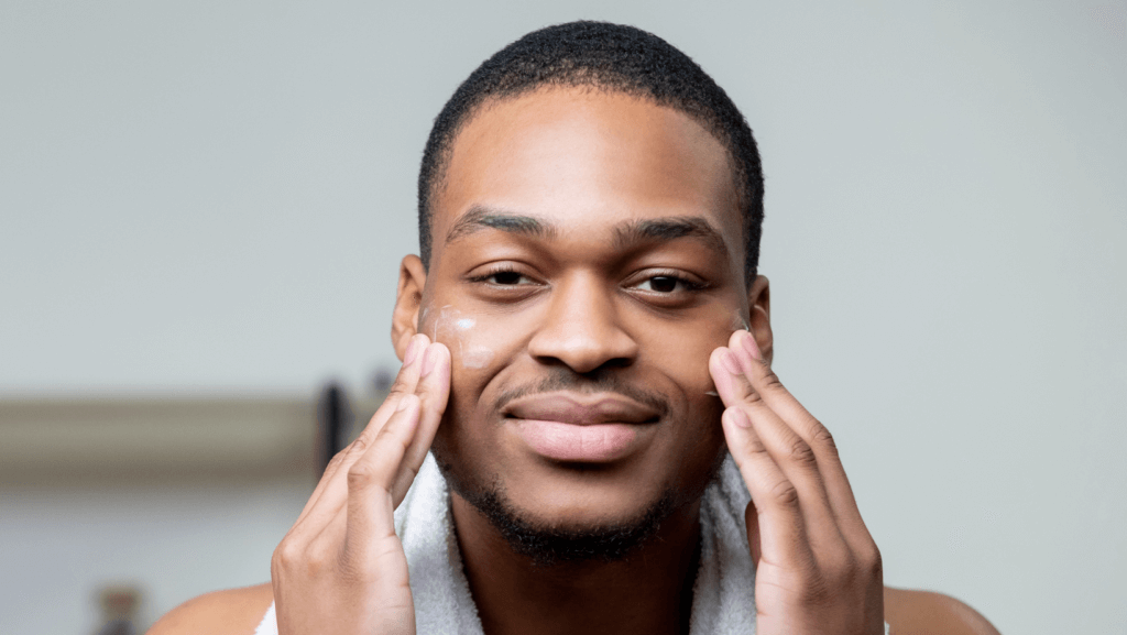 smiling man putting cream on his face