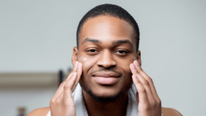 smiling man putting cream on his face