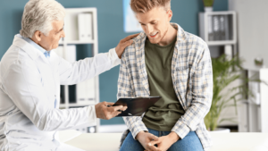 Man in doctor's office receiving compassionate care from doctor