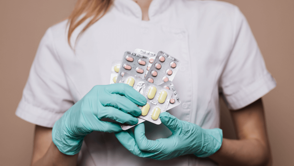 Gloved healthcare professional holding pills