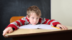 Young boy at desk looking frustrated