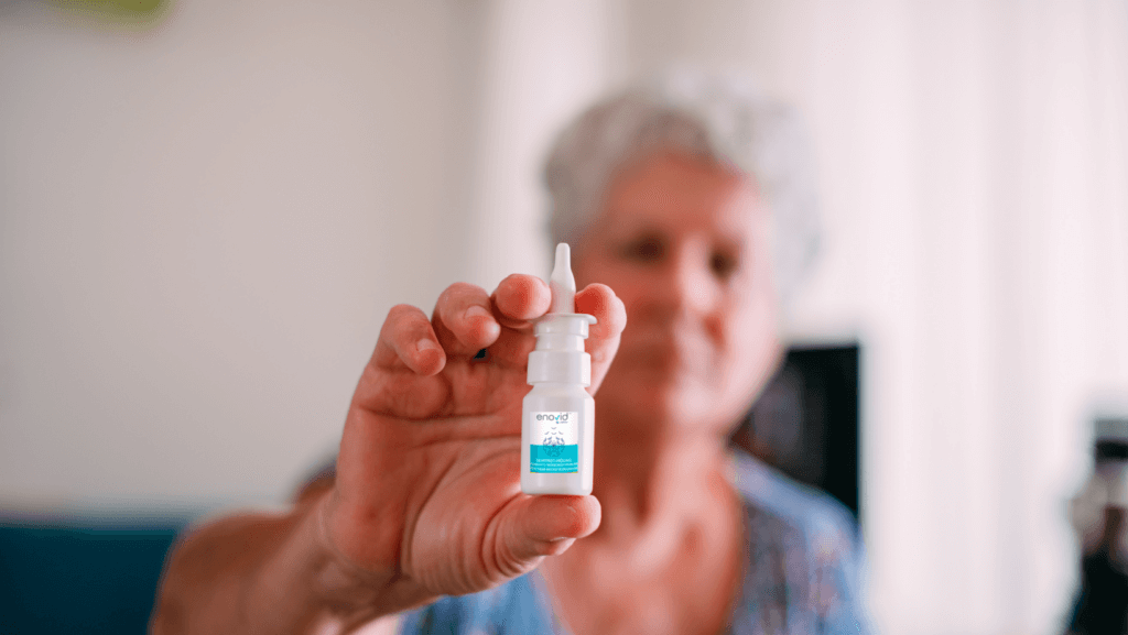 woman holding up a bottle of anti-viral nasal spray