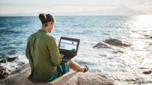 Young digital nomad man working by the sea