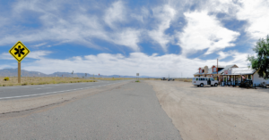 desert highway with sign indicating pharmacy ahead