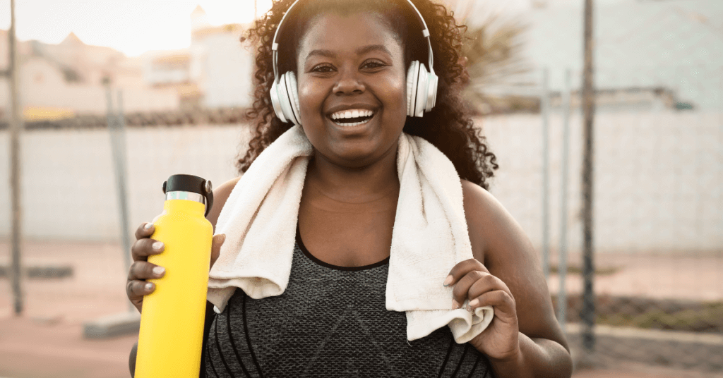 Smiling, healthy woman holding yellow water bottle