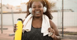 Smiling, healthy woman holding yellow water bottle