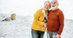 Senior-Couple-in-Sweaters-on-the-Seashore