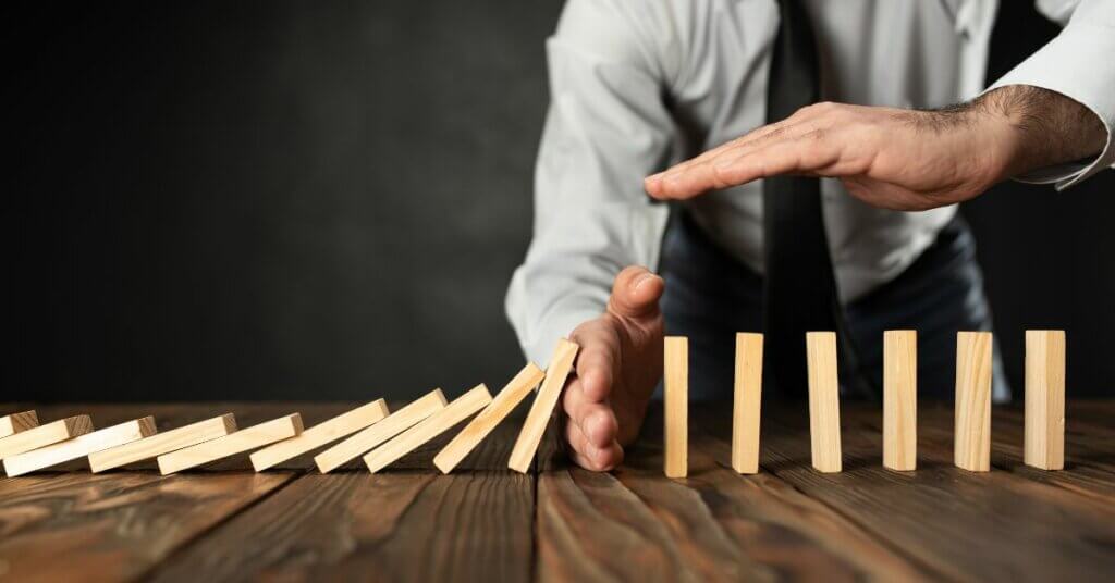 Man-putting-stop-to-domino-effect