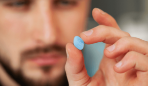 Man holding a Viagra pill