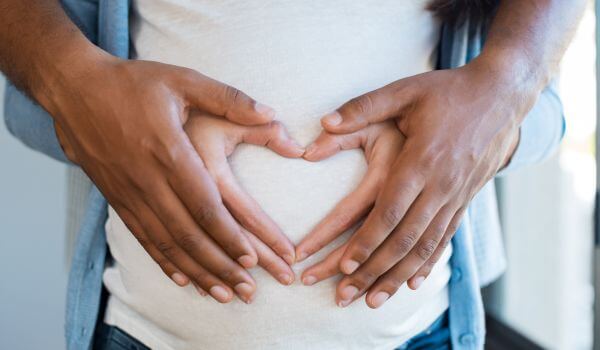 Couple Hear Shape Hands on Pregnant Belly