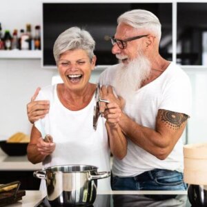 Happy Couple Having Fun while Cooking at Home Kitchen