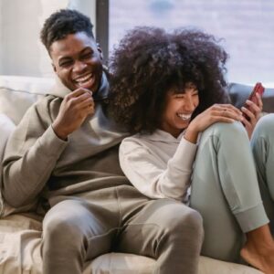 Happy couple on couch with smartphone