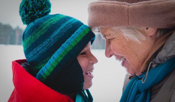 happy grandmother and grandson talk in winter nature