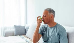 Man Using Asthma Inhaler at Home