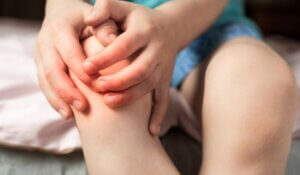 pain in the knee joints of the child. the boy's knees hurt