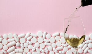 Drugs and alcohol: pills and wine glass