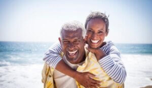 Happy Couple in Piggyback on the Beach