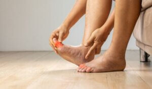 Massaging foot with painful swollen gout inflammation