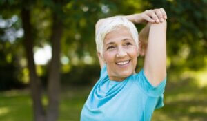 Senior Woman Doing Exercise for Stretching Hand in the Park
