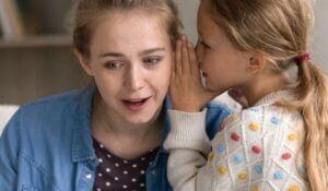 Joyful preteen girl telling secret to mum.