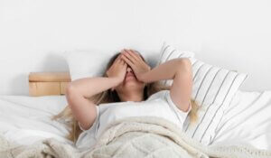 Sleepless Young Woman in Bed at Home