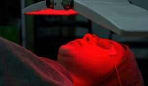 Young woman doing bio light red light therapy on her face