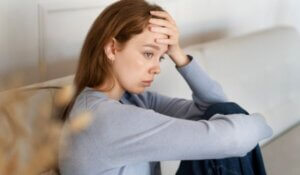 anxious woman sitting couch side view