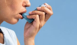 Woman using asthma inhaler during asthma attack 