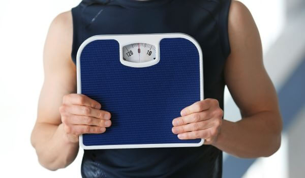 Man Holding Weighing Scale