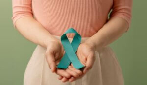 Ovarian and Cervical Cancer Awareness. Woman Holding Teal Ribbon