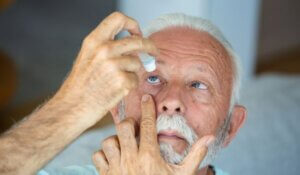 Senior man drops eye drops in eye -moisturizing