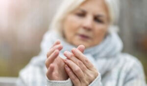 Senior woman with arthritis rubbing hands
