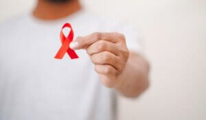 Worlds HIV Aids Day, Men Holding A red ribbon In his hand, HIV Aids Awareness,
