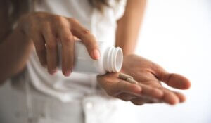 Young woman taking supplements at home