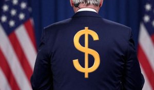 US politician standing with his back to crowd with dollar sign on his back