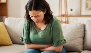 Woman on sofa struggling with IBS pain